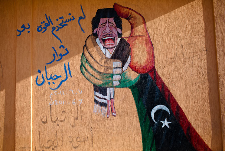 Graffiti depicting Muammar Gaddafi is seen on the wall of an abandoned petrol station on August 24, 2011 near Zintan, Libya.